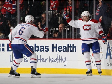 Sven Andrighetto #42 of the Montreal Canadiens celebrates his goal at 14:17 of the second period against the New Jersey Devils and is joined by Greg Pateryn #6 at the Prudential Center on November 27, 2015 in Newark, New Jersey.