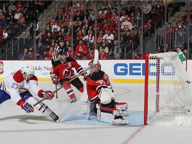 Alex Galchenyuk #27 of the Montreal Canadiens scores a third period goal against Cory Schneider #35 of the New Jersey Devils at the Prudential Center on November 27, 2015 in Newark, New Jersey. The Canadiens defeated the Devils 3-2 in the shootout.