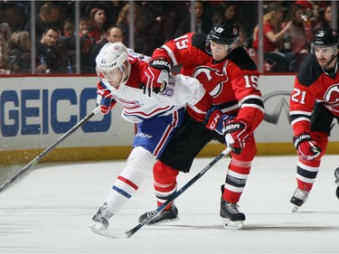 Lars Eller #81 of the Montreal Canadiens is held by Travis Zajac #19 of the New Jersey Devils during the first period at the Prudential Center on November 27, 2015 in Newark, New Jersey.