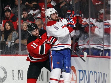 Stephen Gionta #11 of the New Jersey Devils rides Greg Pateryn #6 of the Montreal Canadiens into the boards during the second period at the Prudential Center on November 27, 2015 in Newark, New Jersey.