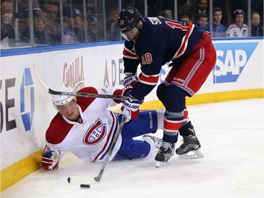 Alexander Semin #13 of the Montreal Canadiens is checked by Marc Staal #18 of the New York Rangers during the first period at Madison Square Garden on November 25, 2015 in New York City.