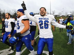Montreal Carabines' Alexandre Doucet (right) celebrates the 25-10 win over the Guelph Gryphons in the CIS Mitchell Bowl football championship game in Guelph, Ont., on Saturday, Nov. 21, 2015.