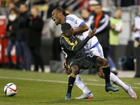 Montreal Impact forward Didier Drogba (11) grimaces as he comes into contact with Columbus Crew defender Harrison Afful (25) during the MLS playoff soccer game at Mapfre Stadium in Columbus, Ohio, on Sunday, Nov. 8, 2015.
