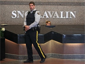 RCMP officers guard the lobby of the SNC-Lavalin building in Montreal as a raid is carried out on offices at the international engineering firm, April 13, 2012.