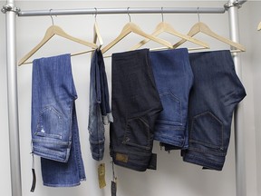 Jeans hang on a rack.