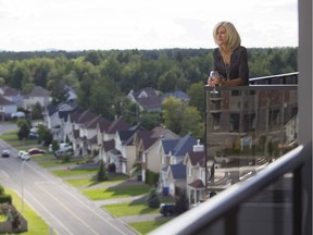 Lilianne Sediva looks out from one of the 2 balconies at the condo she shares with Jocelyn Tremblay in Blainville.  The couple are mature professionals who decided to sell their single-family home in Fontainebleau, a neighbourhood in Blainville, and opt for condo living instead. (John Kenney / MONTREAL GAZETTE)