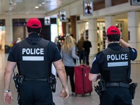 MONTREAL, QUE.: MAY 20, 2015 -- SPVM police officers walk through the departures terminal at the Montréal–Pierre Elliott Trudeau International Airport in Montreal on Wednesday, May 20, 2015. (Dario Ayala / Montreal Gazette)