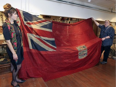 Curator Caitlin Bailey and collector Mark Cahill unfold a red ensign, the Canadian flag during World War 1, at Cahill's Canadian Centre for the Great War, in Montreal Tuesday November 03, 2015.
