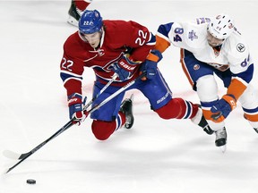 Canadiens' Dale Weise, left, passes the puck while being knocked down by Islanders' Mikhail Grabovski during game in Montreal on Thursday, Nov. 05, 2015.