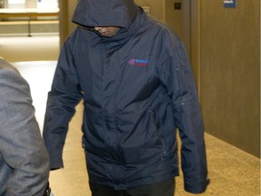 Clinton Sathiyaseelan tries to hide his face as he arrives to testify at the provincial courthouse in Montreal, Tuesday Nov. 10, 2015 at the second-degree murder trial of Abiram Subramaniam.