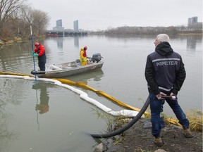 A crew cleans debris from water at the exit to a channel leading from the St Pierre sewage discharge point in Verdun, Nov. 12, 2015. It is the second day that raw sewage is being temporarily discharged into the St. Lawrence River to allow required repairs.