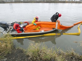 A crew sets up booms to collect debris from raw sewage at the exit to a channel leading from the St Pierre sewage discharge point in Verdun, Montreal, Thursday November 12, 2015.