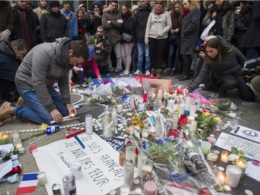 French national Anna Agueb-Porterie holds up a French flag at a vigil outside the French consulate in Montreal Saturday, November 14 , 2015, for victims of the Paris terrorist attacks.