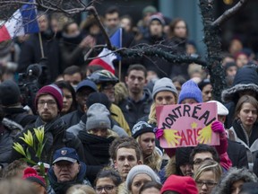 People attend a vigil outside the French consulate in Montreal Saturday, Nov. 14 , 2015, for victims of the Paris terrorist attacks. The Islamic State group claimed responsibility for the attacks in Paris that killed 127 people Friday.