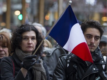 People attend a vigil outside the French consulate in Montreal Saturday, November 14 , 2015, for victims of the Paris terrorist attacks.