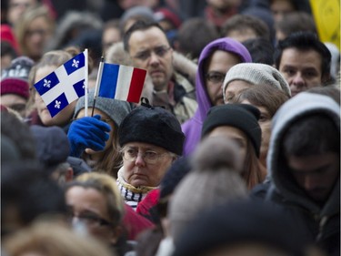 People attend a vigil outside the French consulate in Montreal Saturday, November 14 , 2015, for victims of the Paris terrorist attacks.