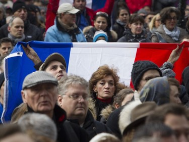 A woman holds a French flag outside the French consulate in Montreal on Sunday, Nov. 15 , 2015, after a march in solidarity with Paris.