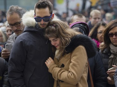 A woman is overcome by emotion outside the French consulate in Montreal on Sunday, Nov. 15 , 2015 after a march in solidarity with Paris.