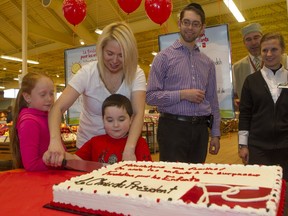 Rachel Ricci, helps 4½-year-old son Coden cutting a cake at Loblaws-Cavendish on Tuesday Nov. 17, 2015. Daughter Capri, far left, looks on. In the middle is Gabriel Kaufman. His 5-year-old son Josef was not present. Three families, each with a child needing special therapy, received grants for the therapy through Loblaws.