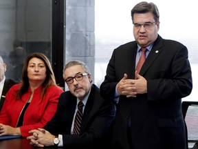 Michel Dorais, centre, listens as Montreal Mayor Denis Coderre convenes a special meeting Nov. 19 about the Syrian refugee crisis.