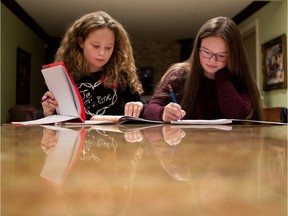 Daniela Maciocia, left, 12 years old, and her sister Eliana Manioca, 14 years old, do homework in the kitchen of their home in Montreal on Tuesday November 24, 2015.