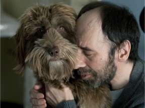 Serge Francoeur embraces a labradoodle named Bibo, at Centre d'hébergement Ernest-Routhier in Montreal.