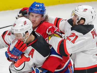 Montreal Canadiens defenceman Jeff Petry, centre, wrestles with New Jersey Devils forwards Travis Zajac, left, and Kyle Palmieri, right, during the second period of their NHL hockey match at the Bell Centre in Montreal on Saturday, November 28, 2015.