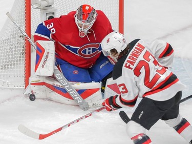 Montreal Canadiens goalie Mike Condon, left, makes a save against New Jersey Devils forward Bobby Farnham, right, during the second period of their NHL hockey match at the Bell Centre in Montreal on Saturday, November 28, 2015.