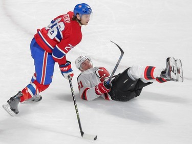 New Jersey Devils forward Sergey Kalinin, right, falls after colliding with Montreal Canadiens defenceman Jeff Petry, left, during the second period of their NHL hockey match at the Bell Centre in Montreal on Saturday, November 28, 2015.