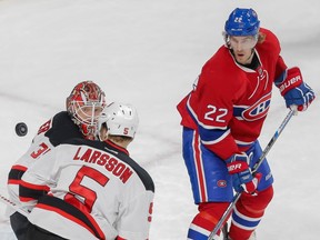 New Jersey Devils goalie Cory Schneider, left, keeps his eye on the puck as it flies past Montreal Canadiens right wing Dale Weise, right, and Devils defenceman Adam Larrson, foreground, during their NHL hockey match at the Bell Centre in Montreal on Saturday, Nov. 28, 2015.
