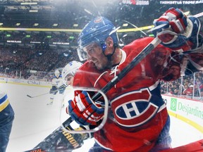 The Canadiens' Torrey Mitchell is bumped against the glass by a St. Louis Blues player during NHL game at the Bell Centre in Montreal on Oct. 20, 2015.