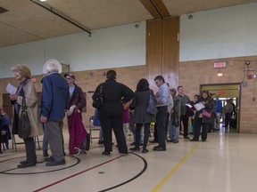 Voters lined up and waited as long as 1 and a half hours to vote at St. Monica Elementary School during the advance polls for school board election in Montreal, on Sunday, October 26, 2014.