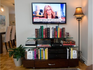 A stand filled with books is under the wall-mounted television. (Allen McInnis / MONTREAL GAZETTE)