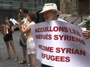 Robert Verrall urged passersby outside the St. James United Church in September to welcome Syrian refugees.