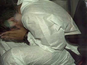 Nicholas Fontanelli hides from photographers as he arrives at the courthouse to be charged with first-degree murder of his fiancee, Samantha Higgins, Tuesday, July 14, 2015 in Montreal.