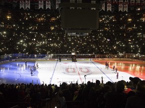 The French flag is illuminated on the ice before game between the Canadiens and the Colorado Avalanche at the Bell Centre in Montreal on Nov. 14, 2015.