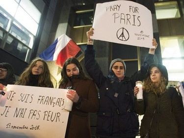 People attend a vigil outside the French consulate in Montreal, Friday, November 13, 2015. Canadian Prime Minister Justin Trudeau offered "all of Canada's support" to France on Friday night in the wake of "deeply worrying" terrorist attacks in Paris.