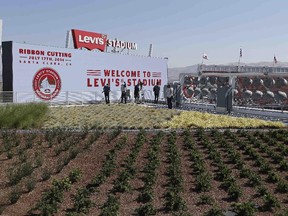 People take pictures from the NRG Solar Terrace and green roof before the ribbon-cutting and opening of Levi's Stadium Thursday, July 17, 2014, in Santa Clara, Calif. The San Francisco 49ers held a ribbon-cutting ceremony to officially open their new home. The $1.2 billion Levi's Stadium, which took only about 27 months to build, also will host the NFL Super Bowl in 2016 and other major events. The 27,000 square foot space on the roof features 16 native plants, with over 5,000 square feet of room for hospitality as well.