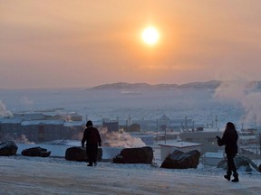 People walk along a path in Iqaluit, Nunavut on Tuesday, December 9, 2014. A long-running study concludes that the well-being of northerners in Canada's Arctic compares poorly with those in many other Arctic regions around the world.