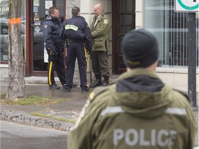 RCMP and Sûreté du Québec police officers stand outside the offices of Rizzuto family lawyer Loris Cavaliere Nov. 19, 2015.