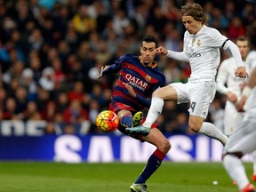 Real Madrid's Luka Modric fights for the ball with Barcelona's Sergio Busquets, left, during the first clasico of the season between Real Madrid and Barcelona at the Santiago Bernabeu stadium in Madrid, Spain, Saturday, Nov. 21, 2015.