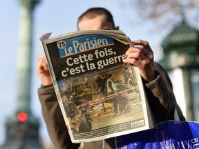 A man reads a French newspaper after a terrorist attack on November 14, 2015 in Paris, France.