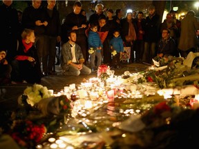 Flowers and candles are left on the pavement near the scene of Bataclan Theatre terrorist attacks on Nov. 14, 2015, in Paris.