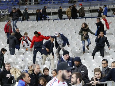 Soccer fans leave the Stade de France stadium after an international friendly soccer match in Saint Denis, outside Paris, Friday, Nov. 13, 2015. An explosion occured outside the stadium. Several dozen people were killed in a series of attacks around Paris on Friday, French President Francois Hollande said, announcing that he was closing the country's borders and declaring a state of emergency.