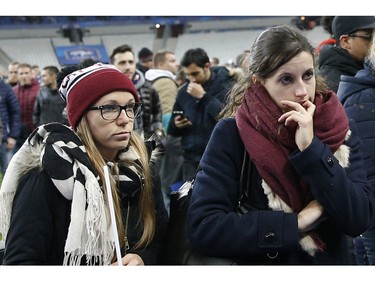 Soccer fans wait on the fitch of the Stade de France stadium after an international friendly soccer match in Saint Denis, outside Paris, Friday, Nov. 13, 2015. An explosion occurred outside the stadium. Several dozen people were killed in a series of unprecedented attacks around Paris on Friday, French President Francois Hollande said, announcing that he was closing the country's borders and declaring a state of emergency.