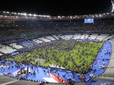 Spectators invade the pitch of the Stade de France stadium after the international friendly soccer France against Germany, Friday, Nov. 13, 2015 in Saint Denis, outside Paris. At least 35 people were killed in shootings and explosions around Paris, police and medical officials said Friday.  Two explosions were heard outside the Stade de France stadium.