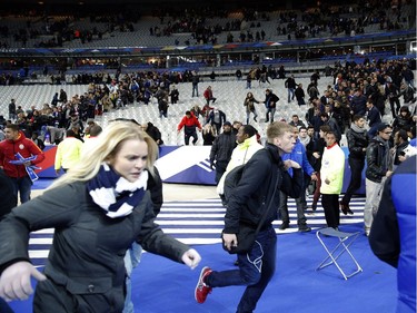 Spectators run onto the pitch of the Stade de France stadium after the international friendly soccer match between France and Germany in Saint Denis, outside Paris, Friday, Nov. 13, 2015. Hundreds of people spilled onto the field of the Stade de France stadium after explosions were heard nearby during a friendly match between the French and German national soccer teams. French President Francois Hollande announced the closing of the country's borders and declaring a state of emergency after several dozen people were killed in a series of unprecedented terrorist attacks.