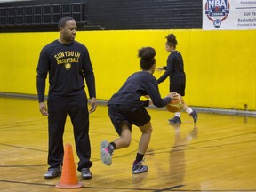 Volunteer basketball coach Farid Charles runs drills with two athletes at Sun Youth.
