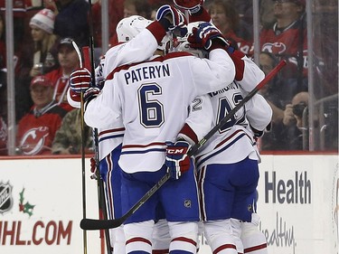 Montreal Canadiens celebrate a goal by Sven Andrighetto (42), of the Czech Republic, during the second period of an NHL hockey game against the New Jersey Devils, Friday, Nov. 27, 2015, in Newark, N.J.