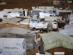 File photo: Syrian refugees stand outside their tents at a Syrian refugee camp in the town of Hosh Hareem, in the Bekaa valley, east Lebanon, on Oct. 28, 2015.